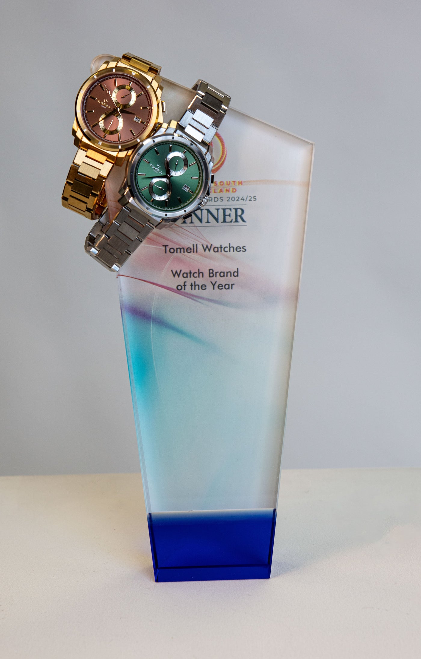 A hero shot of a polished silver chronograph and a gold chronograph side-by-side.