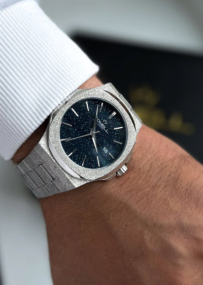 Silver watch with a blue face on a wrist for men