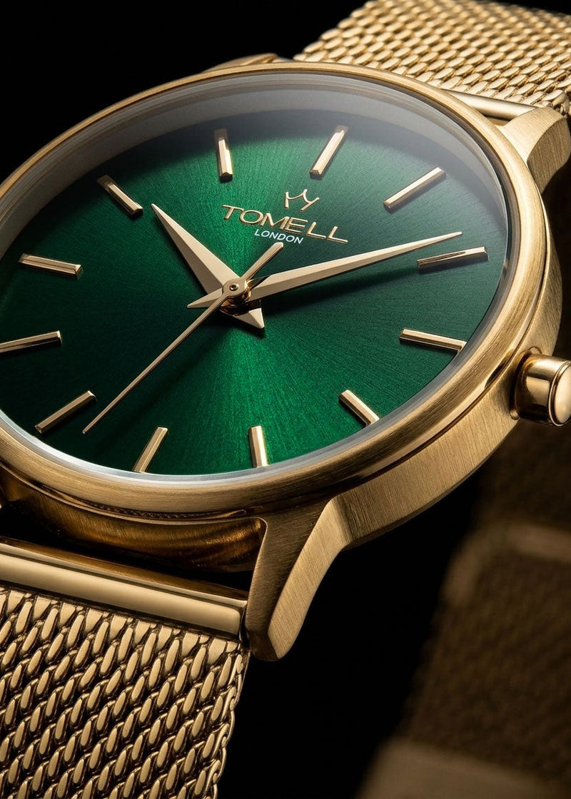 Gold watch with green face and visible brand logo on a dark background
