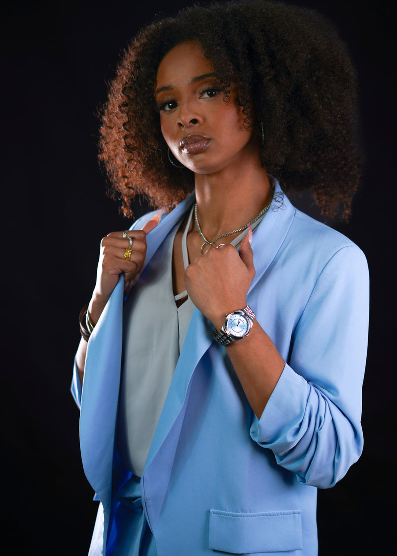 A high-definition shot capturing the blend of British structural design and cool silver accents. The watch boasts a grain-rich steel texture and a shimmering indigo-toned background, prioritizing heritage-bonded durability and steeled quality for the 2026 visionary.