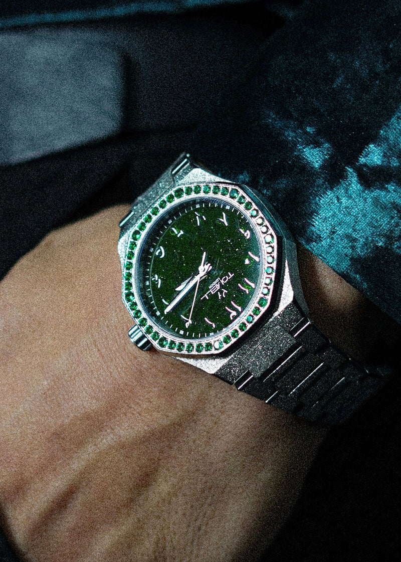 Elegant silver dress watch under £500 with a distinctive frosted finish, sparkling green diamond bezel, and a dark green stardust dial for a formidable presence.