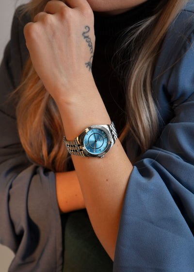 Close-up of the blue watch face highlighting the diamond stone accent at the hour mark.