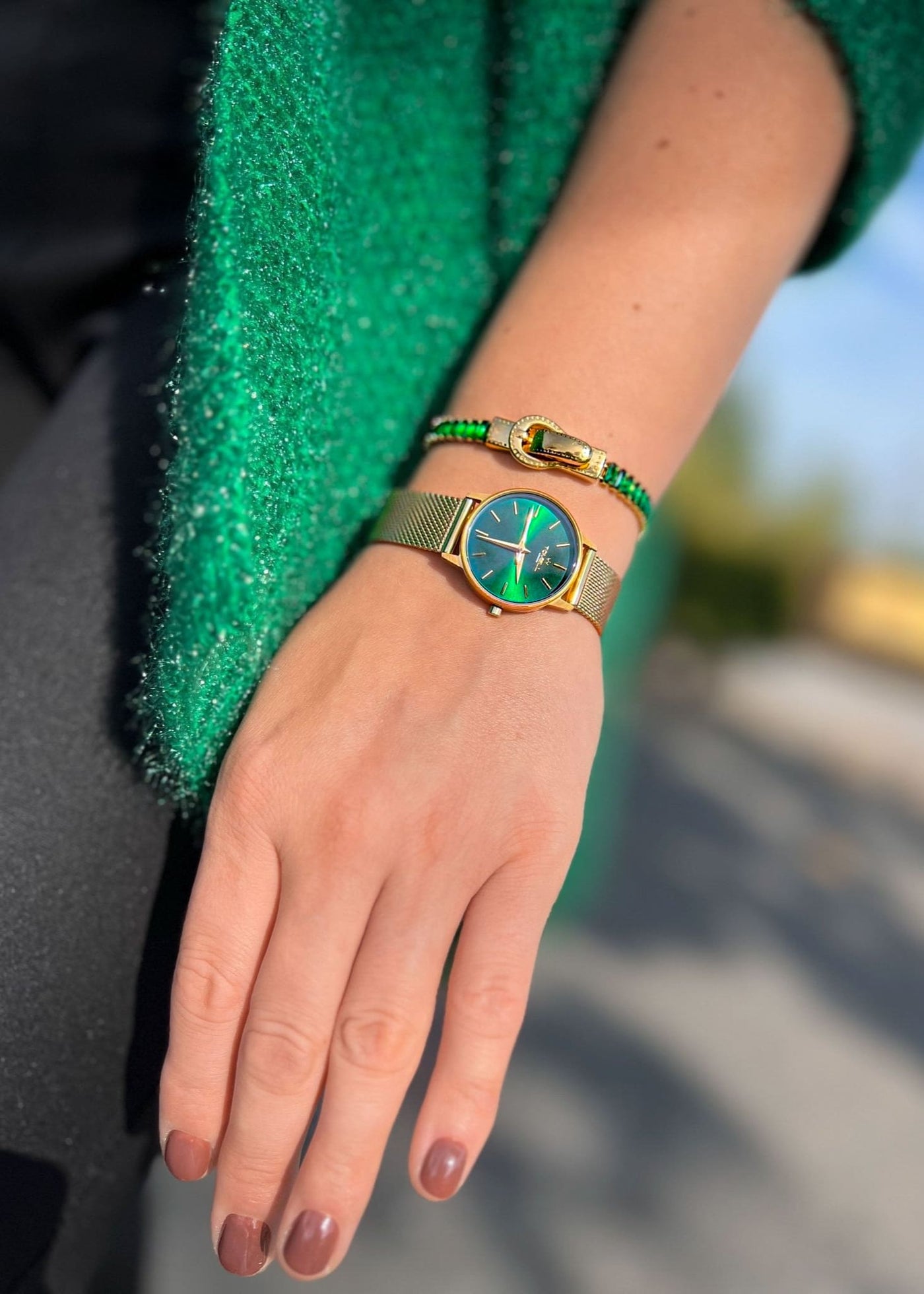 gold watch with a green face, green bracelet