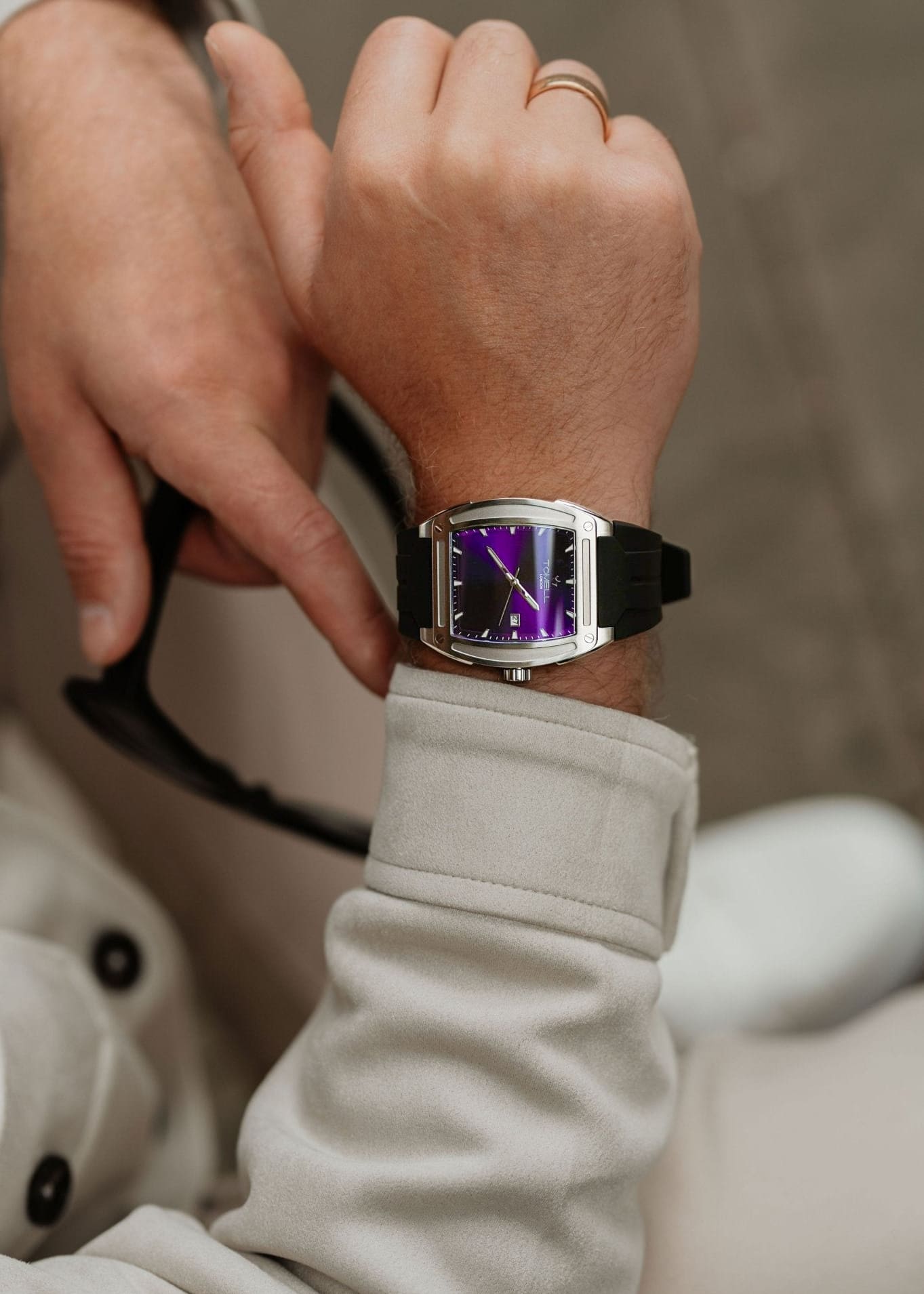 Person wearing a watch with a purple face 