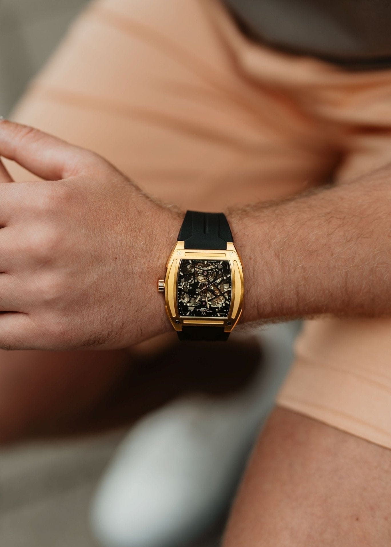 Gold watch with black face skeleton design