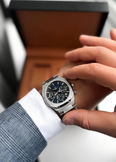 silver watch with a blue face that perfect fits for suite 