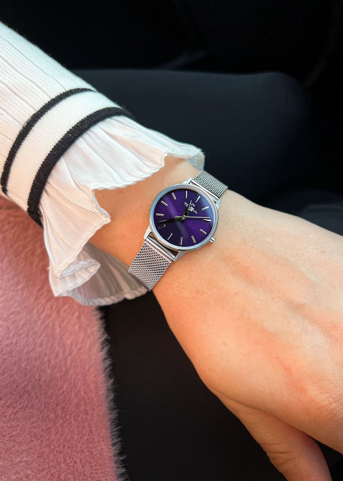 Silver watch with a purple face 